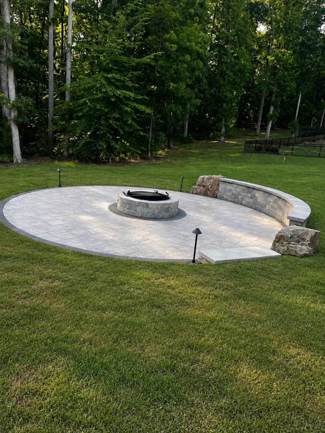 Finished round paver patio with built-in fire pit and seat wall, Kernersville NC